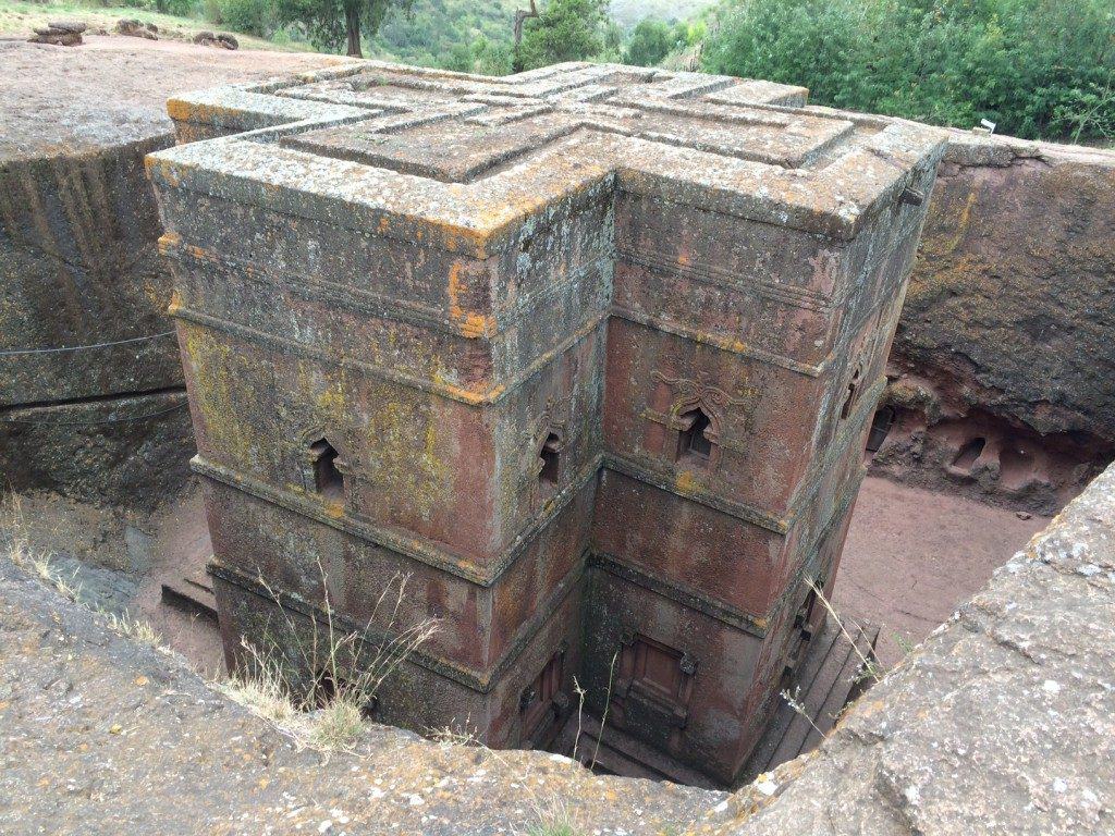 Ancient fortress ruin with colorful mossy stone walls, historical site surrounded by nature.