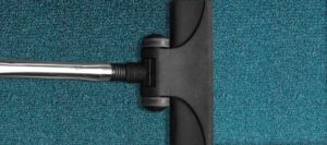 Vacuum cleaner on a blue carpet, promoting safety awareness for kids about household cleaning tools.