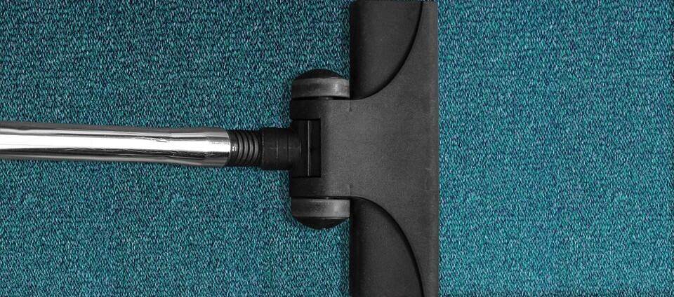 Vacuum cleaner on a blue carpet, promoting safety awareness for kids about household cleaning tools.
