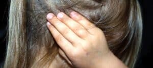 Child's hand covering ear to block out noise, illustrating the importance of safety and noise awareness for kids.
